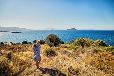 Bodrum, Türkiye'de güneşli gün, mavi gökyüzü ile deniz manzaralı zevk plaj şapkalı güzel bir kadın. Tatil açık havada deniz manzarası yaz seyahat kavramı