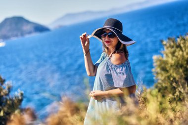 Bodrum, Türkiye'de güneşli gün, mavi gökyüzü ile deniz manzaralı zevk plaj şapkalı güzel bir kadın. Tatil açık havada deniz manzarası yaz seyahat kavramı