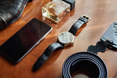 Bir iş adamının farklı aksesuarları ahşap bir arka planda yatar.