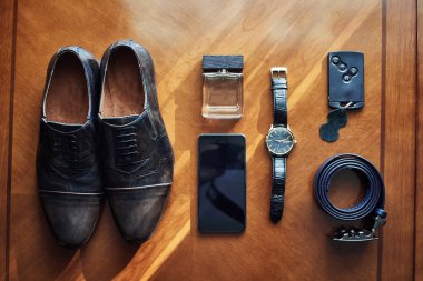 Bir iş adamının farklı aksesuarları ahşap bir arka planda yatar.