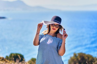 Bodrum, Türkiye'de güneşli gün, mavi gökyüzü ile deniz manzaralı zevk plaj şapkalı güzel bir kadın. Tatil açık havada deniz manzarası yaz seyahat kavramı