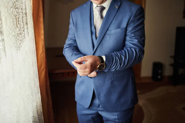 Empresario lleva una chaqueta, manos masculinas primer plano, novio consiguiendo readBusinessman lleva una chaqueta, manos masculinas primer plano, novio preparándose en la mañana antes de la ceremonia de boda —  Fotos de Stock