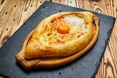 Acaralı Khachapuri geleneksel Gürcü peynir pasta kesme tahtası üzerinde yumurta ile. Homemade pişirme. Açık pasta Mozzarella peyniri ile 