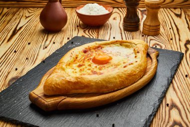 Acaralı Khachapuri geleneksel Gürcü peynir pasta kesme tahtası üzerinde yumurta ile. Homemade pişirme. Açık pasta Mozzarella peyniri ile 