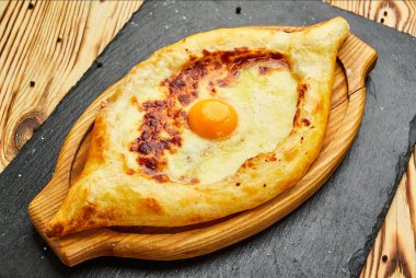 Acaralı Khachapuri geleneksel Gürcü peynir pasta kesme tahtası üzerinde yumurta ile. Homemade pişirme. Açık pasta Mozzarella peyniri ile 