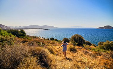 Bodrum, Türkiye'de güneşli gün, mavi gökyüzü ile deniz manzaralı zevk plaj şapkalı güzel bir kadın. Tatil açık havada deniz manzarası yaz seyahat kavramı