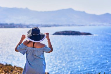 Bodrum, Türkiye'de güneşli gün, mavi gökyüzü ile deniz manzaralı zevk plaj şapkalı güzel bir kadın. Tatil açık havada deniz manzarası yaz seyahat kavramı