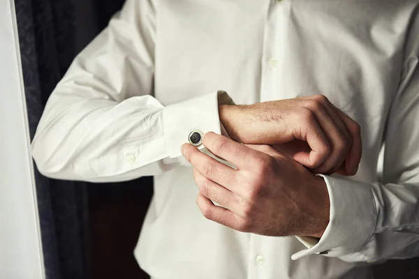 Homme d'affaires robes chemise blanche, les mains masculines gros plan, marié se préparer le matin avant la cérémonie de mariage — Photo