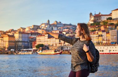 Güzel manzara eski şehir (Ribeira tarihi üç ay) ve nehir Duoro gün batımı sırasında Portekiz Porto şehir içinde manzarayı genç kadın turist