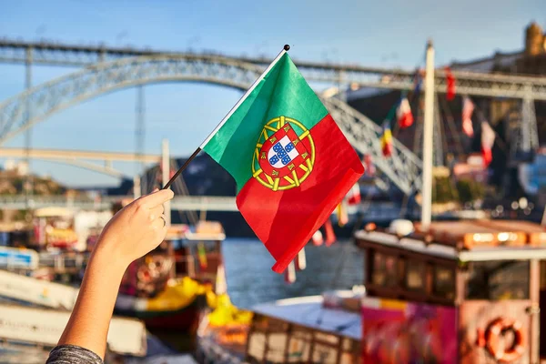 Portugalski flaga jako symbol Portugalii na tle mostu Ponte de Dom Luis I na nasyp w pobliżu rzeki Doure w Porto — Zdjęcie stockowe