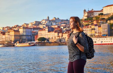 Güzel manzara eski şehir (Ribeira tarihi üç ay) ve nehir Duoro gün batımı sırasında Portekiz Porto şehir içinde manzarayı genç kadın turist