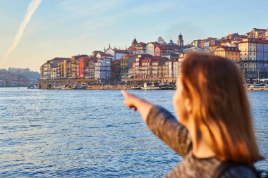 Güzel manzara eski şehir (Ribeira tarihi üç ay) ve nehir Duoro gün batımı sırasında Portekiz Porto şehir içinde manzarayı genç kadın turist