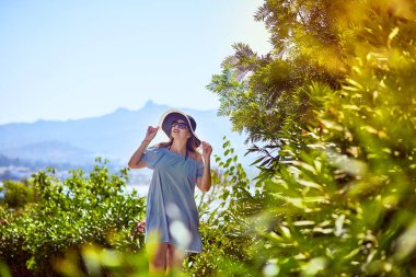 Bodrum, Türkiye'de güneşli gün, mavi gökyüzü ile deniz manzaralı zevk plaj şapkalı güzel bir kadın. Tatil açık havada deniz manzarası yaz seyahat kavramı