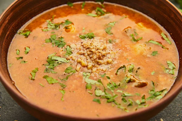 Tradycyjna zupa gruziński Kharcho z mięsa i ryżu na ciemnym tle kamień — Zdjęcie stockowe