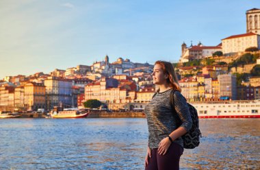 Güzel manzara eski şehir (Ribeira tarihi üç ay) ve nehir Duoro gün batımı sırasında Portekiz Porto şehir içinde manzarayı genç kadın turist