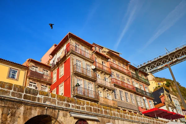 Colorful houses of Porto Ribeira, traditional facades, old multi-colored buildings with red roof tiles on the embankment in the city , Portugal