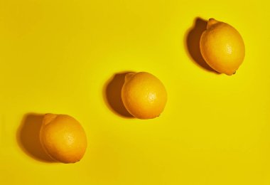 Sarı arka planda limon. Düz yatıyordu, üst görünüm, kopya alanı. Gıda konsepti.