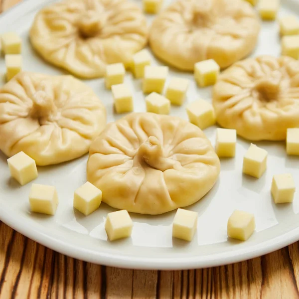 Georgische Knödel Chinkali mit Käse, Gemüse und Tomaten würzige Sauce satsebeli auf weißem Teller — Stockfoto