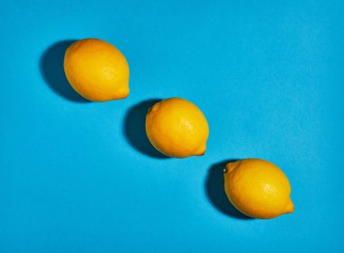 Mavi arka planda limon. Düz yatıyordu, üst görünüm, kopya alanı. Gıda konsepti.