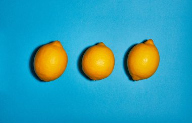 Mavi arka planda limon. Düz yatıyordu, üst görünüm, kopya alanı. Gıda konsepti.