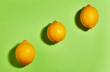 Yeşil arka planda limon. Düz yatıyordu, üst görünüm, kopya alanı. Gıda konsepti.