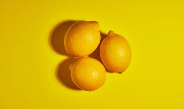 Sarı arka planda limon. Düz yatıyordu, üst görünüm, kopya alanı. Gıda konsepti.