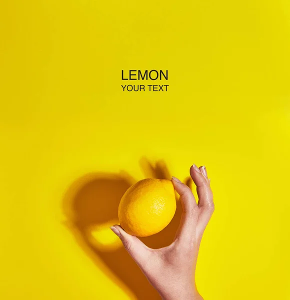 Diseño creativo hecho de limón en mano sobre fondo amarillo. Piso tendido, vista superior, espacio para copiar. Concepto alimenticio . — Foto de Stock