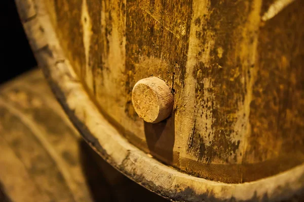 Old aged traditional wooden barrels with wine in a vault lined up in cool and dark cellar in Italy, Porto, Portugal, France
