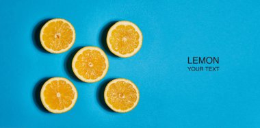 Mavi arka planda limon yapılmış yaratıcı düzeni. Düz yatıyordu, üst görünüm, kopya alanı. Gıda konsepti.