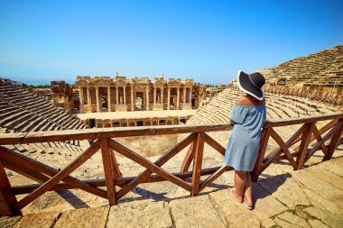 Antik Hierapolis, Pamukkale, Türkiye'deki muhteşem Amfitiyatro kalıntılarına şapkalı kadın gezginin arka görünümü. Büyük panorama