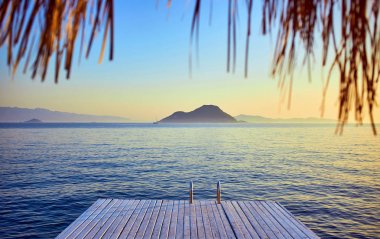 Gün batımında denizde bungalov. Kumlu bir plajın kıyısında ahşap köşkler - Bodrum, Türkiye 