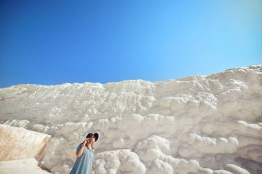 Şapkalı genç kız Pamukkale 'deki travertin havuzlarına ve teraslara bakıyor. Türkiye 'nin güneybatısındaki pamuk kale