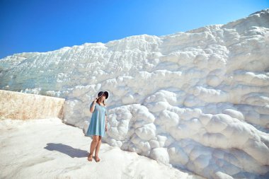 Şapkalı genç kız Pamukkale 'deki travertin havuzlarına ve teraslara bakıyor. Türkiye 'nin güneybatısındaki pamuk kale