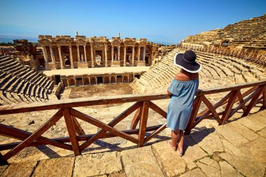 Antik Hierapolis, Pamukkale, Türkiye'deki muhteşem Amfitiyatro kalıntılarına şapkalı kadın gezginin arka görünümü. Büyük panorama