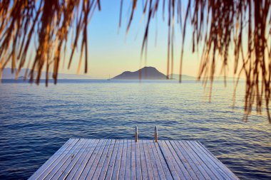 Gün batımında denizde bungalov. Kumlu bir plajın kıyısında ahşap köşkler - Bodrum, Türkiye 