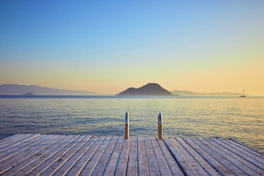 Gün batımında denizde bungalov. Kumlu bir plajın kıyısında ahşap köşkler - Bodrum, Türkiye 