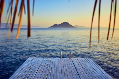 Gün batımında denizde bungalov. Kumlu bir plajın kıyısında ahşap köşkler - Bodrum, Türkiye 