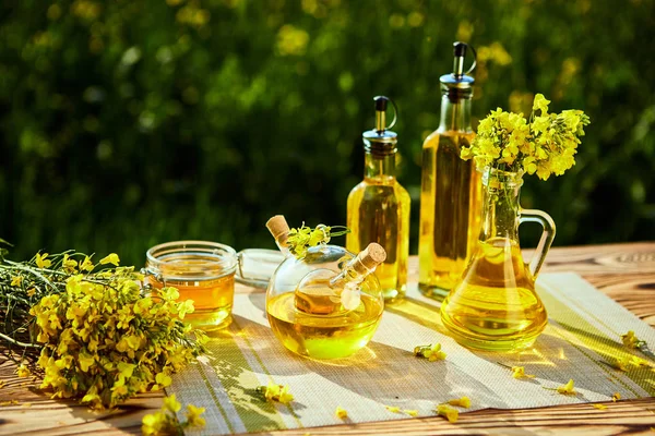 Rapeseed oil bottles (canola) on background rape field