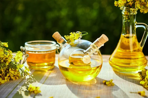 Rapeseed oil bottles (canola) on background rape field