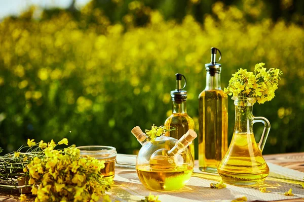 Lahve řepkového oleje (canola) na pozadí řepky pole — Stock fotografie