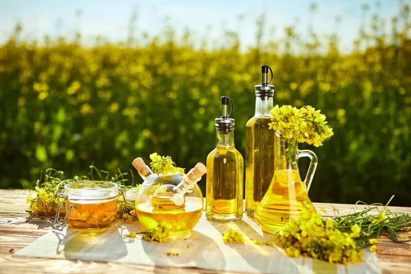 Rapeseed oil bottles (canola) on background rape field