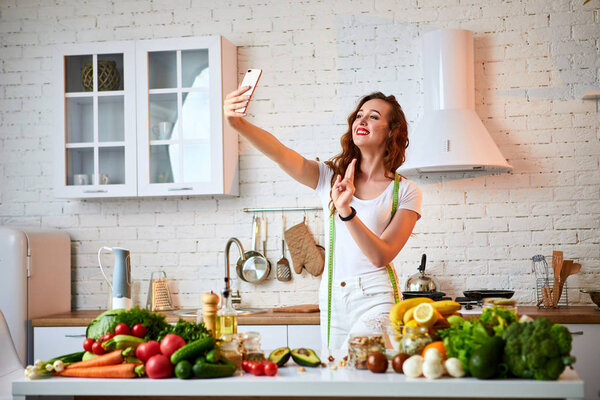 Young beautiful woman take a selfie while cooking in the modern kitchen. Healthy food and Dieting concept. Losing Weight