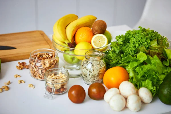 Nezpracovaná organická zelenina, ovoce a ořechy s čerstvými ingrediencemi pro zdravě vaření na kuchyni. Pojem vegan nebo dietní jídlo. Zdravý životní styl a stravování — Stock fotografie