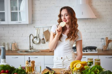 Genç kadın mutfakta çavdar krakergevrek ekmek yiyor. Sağlıklı yaşam tarzı. Sağlık, Güzellik, Diyet Kavramı.