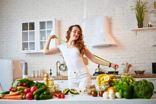 Žena, která měří perfektní tvar krásného pasu se zelenou páskou (centimetr). Zdravý životní styl a jídlo. Zdraví, krása, dietní koncepce. — Stock fotografie