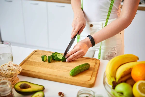 Fiatal boldog nő vágás uborka készítésére saláta a gyönyörű konyhában, zöld friss alapanyagokból beltérben. Egészséges táplálkozás és a fogyókúra fogalmát. Elvesztése súly — Stock Fotó