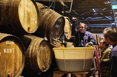 Porto, Portekiz - 10 Aralık 2018: Taylor'ın şarap mahzeninde variller. İşçiler portwine kalitesini kontrol