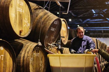 Porto, Portekiz - 10 Aralık 2018: Taylor'ın şarap mahzeninde variller. İşçiler portwine kalitesini kontrol