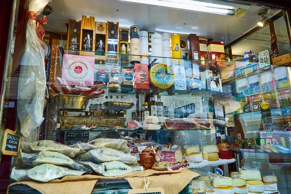 PORTO, PORTUGAL - 9 de dezembro de 2018: bacalhau português seco e salgado (bacalhau), queijo, enlatado e vinho do Porto na loja local do Porto — Fotografia de Stock