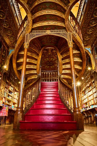 Gran escalera de madera con escalones rojos dentro de la librería Livraria Lello en el centro histórico de Oporto, famosa por la película de Harry Potter . — Foto de Stock